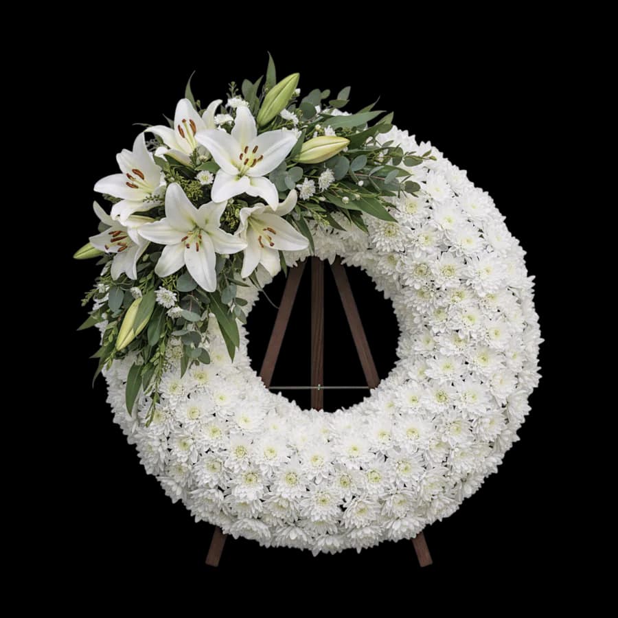 Coroană funerară rotundă albă cu crini albi și crizanteme pe stativ